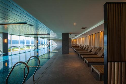 a building with a pool with benches and a glass floor at Hotel Tops 10 in Gangneung