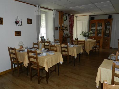 une salle à manger avec des tables, des chaises et un tissu de table jaune dans l'établissement Hotel du Mont Blanc, à Sallanches