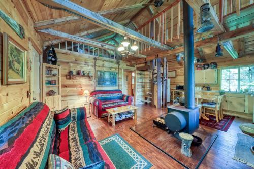 a log cabin living room with a couch and a tv at The Creekside Cabin in Cascade