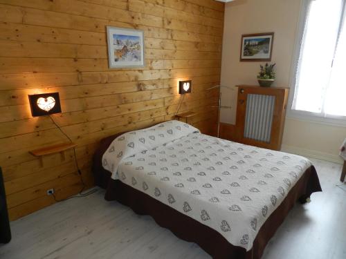 ein Schlafzimmer mit einem Bett in einer Holzwand in der Unterkunft Hotel du Mont Blanc in Sallanches