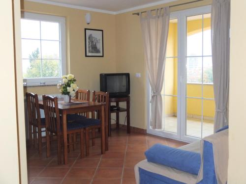 a living room with a table and a tv at Guesthouse Villa AnnaDora in Brseč