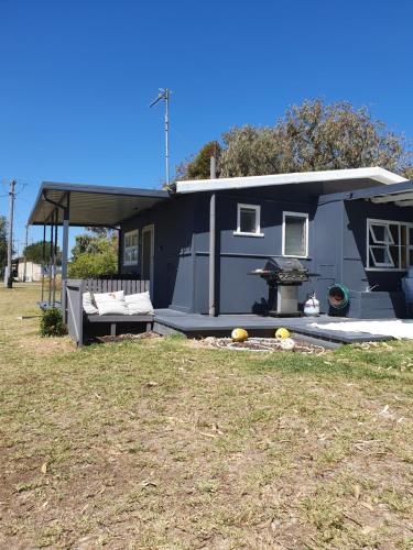 une maison bleue avec un grill dans une cour dans l'établissement Just Chillin, à Lancelin