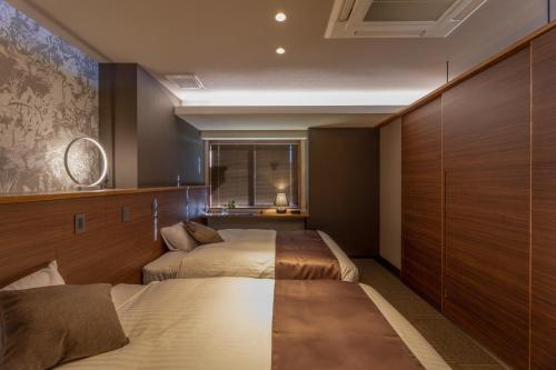 Habitación de hotel con 2 camas y ventana en ITADAKI Daisen 大山参道ホテル頂, en Daisen