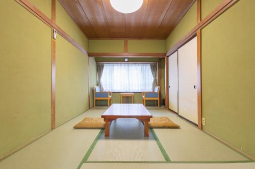 a room with a table and chairs and a window at Hanamizuki in Yamanakako