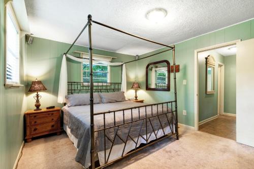 1 dormitorio con cama con dosel en una habitación con paredes verdes en River Romance, en Sylva