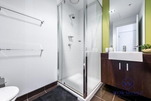 a bathroom with a glass shower and a sink at WOW Apartment on Swanston in Melbourne
