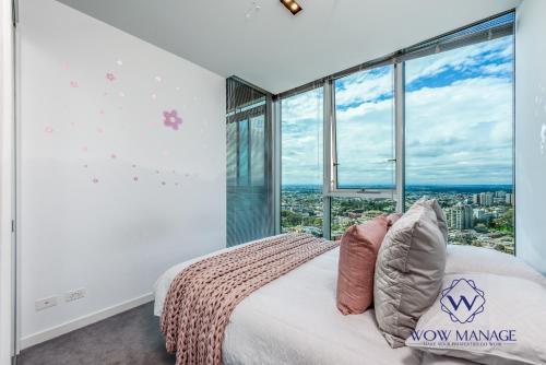 a bedroom with a bed and a large window at WOW Apartment on Swanston in Melbourne