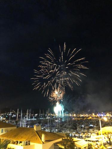 a fireworks display in the sky over a marina at Hôtel Baptistin in Le Lavandou