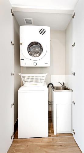 a washing machine in a laundry room with a sink at Manhattan Apartments - Glen Iris in Melbourne