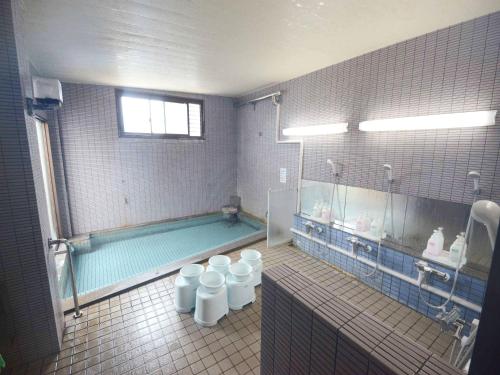 a bathroom with a swimming pool and two toilets at Hanagoyomi in Nanao