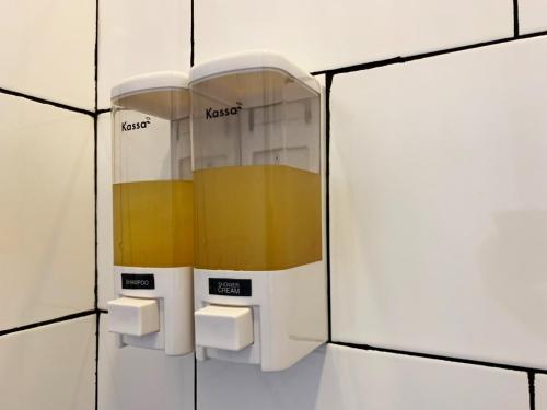 a coffee dispenser on a white tiled wall at Mini-ME Home, A Cozy Entire House in Old City in Chiang Mai