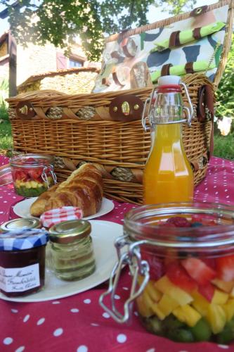 - une table de pique-nique avec de la nourriture et une corbeille de pain et de fruits dans l'établissement Petit Maison du Chêne, à Auriac-du-Périgord