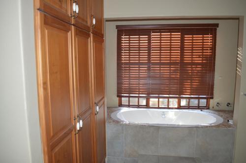 a bath tub in a bathroom with a window at Lake Sands Manor in Pietermaritzburg