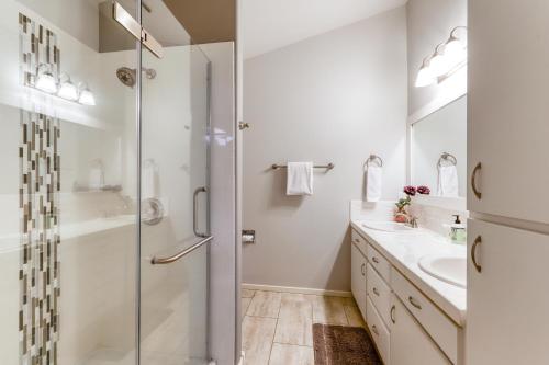 a white bathroom with a shower and a sink at Perfectly Placed Plum Cottage in Bend