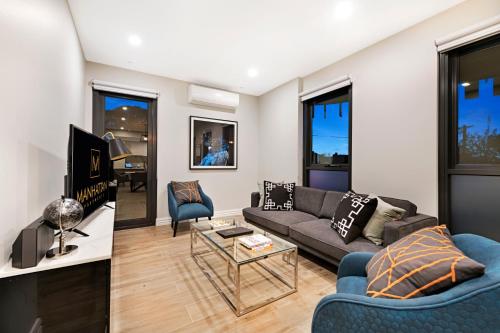 a living room with a couch and a table at Manhattan Apartments - Glen Iris in Melbourne