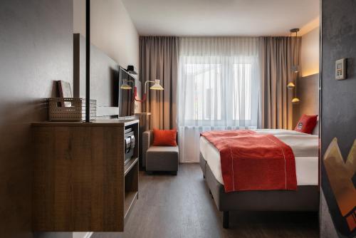 een hotelkamer met een bed en een stoel bij the niu Hide in Berlijn