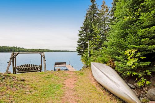 a boat sitting on the side of a lake at High Lake Hideaway in Boulder Junction
