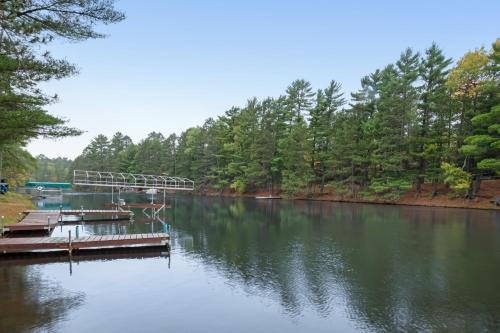 a dock on a lake with trees on the shore at Cast Away in Manitowish Waters