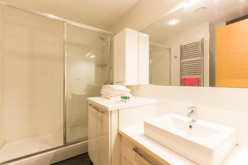 a white bathroom with a sink and a shower at CTS Elysium Residence Taksim in Istanbul