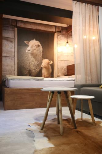 a mural of two sheep on a bed with two tables at Aparthotel Narciarska 2 in Korbielów