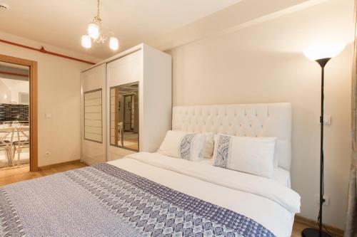 a bedroom with a large white bed with a lamp at CTS Elysium Residence Taksim in Istanbul
