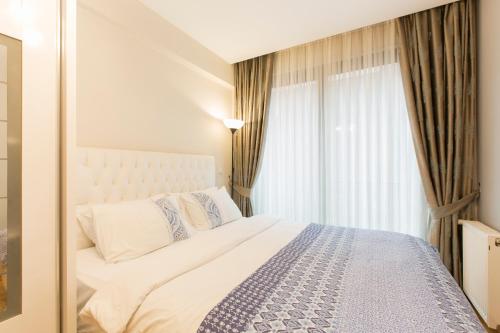 a bedroom with a bed and a large window at CTS Elysium Residence Taksim in Istanbul
