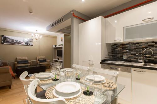 a dining room with a glass table and white chairs at CTS Elysium Residence Taksim in Istanbul