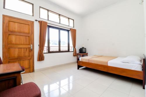 a bedroom with a bed and a window at Hotel Wismancala Kaliurang in Kaliurang