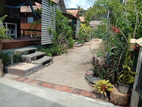 a garden with benches and plants next to a house at Sleep Whale Lanta in Ko Lanta