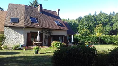 une maison avec des parasols dans la cour dans l'établissement à l'orée du bois, à Bois-Jérôme-Saint-Ouen