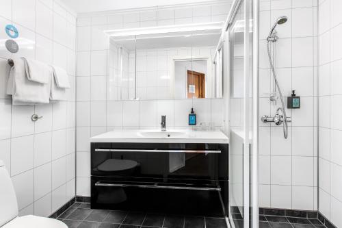 a white bathroom with a sink and a mirror at Comfort Hotel Fosna in Kristiansund