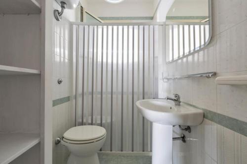 bagno con servizi igienici, lavandino e specchio di Villa LA CAPANNELLA a Nardò