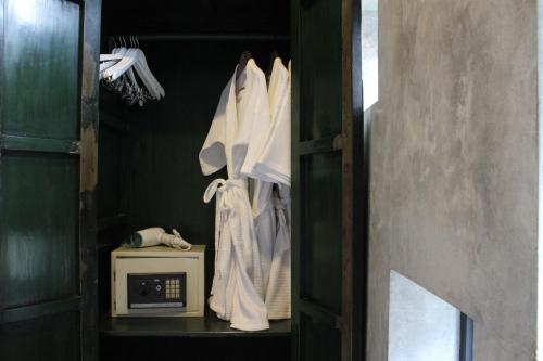 a closet with white towels and a microwave at Villa Thapae in Chiang Mai