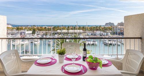 una mesa con un plato de comida y vistas al puerto en Apart-rent Apartamento Port Grec 0175, en Empuriabrava