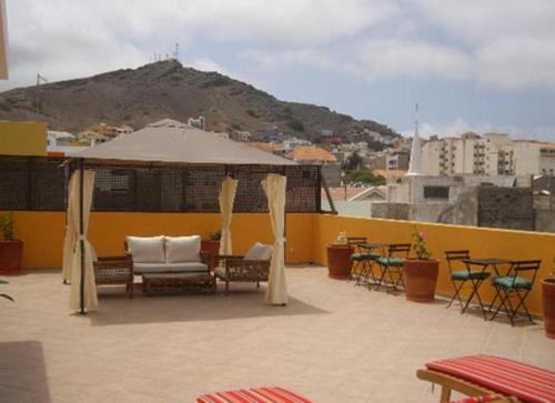 a patio with a gazebo and chairs and tables at Kira's Boutique Hotel in Mindelo