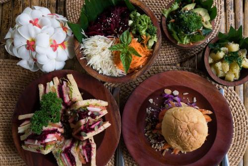 吉利美诺Seri Resort Gili Meno - Adults Only的桌子上的一组盘子里的食物