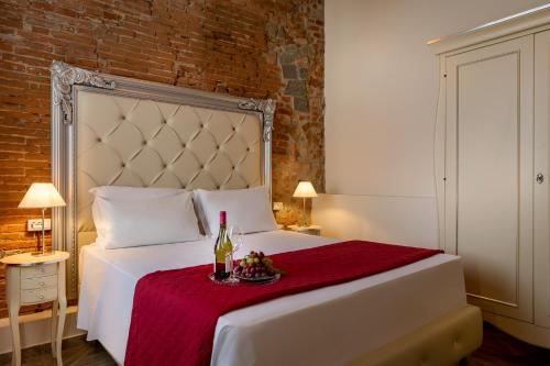 a bedroom with a white bed with a bottle of wine at Residenza Conte di Cavour & Rooftop in Florence