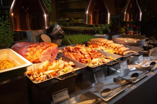 a buffet with several trays of food on a table at Avani Plus Riverside Bangkok Hotel in Bangkok