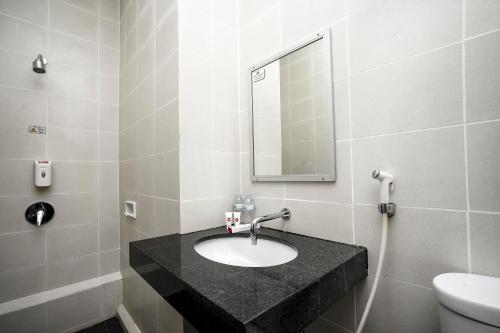 a bathroom with a sink and a mirror at Hotel Grand Kartika in Samarinda