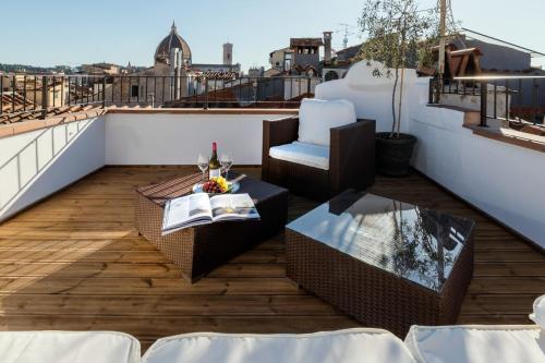 a balcony with a table and chairs on a roof at Residenza Conte di Cavour & Rooftop in Florence