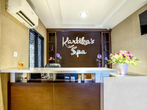 a salon with a table and flowers in a room at Hotel Grand Kartika in Samarinda