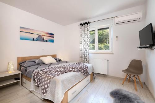 a bedroom with a bed and a tv and a window at House Casetta Filip in Krnica