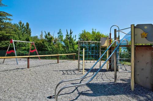 a playground with two swings and a monkey bars at Village Club Les Hyvans in Chorges