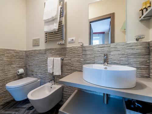 a bathroom with a white sink and a toilet at Foro Romano Luxury Suites in Rome