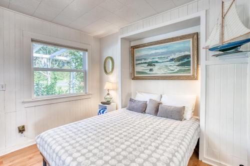 a white bedroom with a bed and a window at Baerfoot Bungalow in Cannon Beach