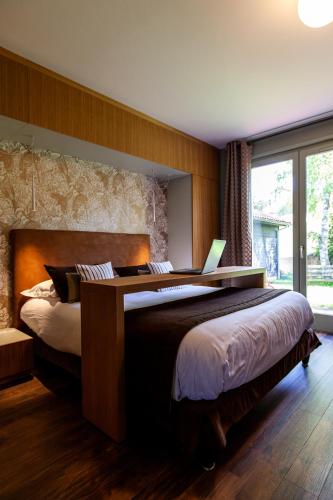 - une chambre avec 2 lits et un ordinateur portable dans l'établissement Logis Hotel Restaurant La Tour, à Dunières