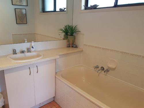 a bathroom with a sink and a bath tub at Coora 13 in Rainbow Beach