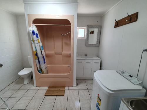 a bathroom with a shower with a toilet and a sink at Number 1 Beach House in Rainbow Beach