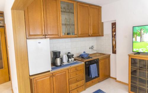 a kitchen with wooden cabinets and a white refrigerator at Аpartment Gem in Centre of Sandanski in Sandanski