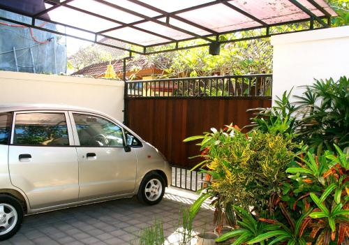 a small silver car parked in front of a fence at Villa Chinta 1 in Sanur